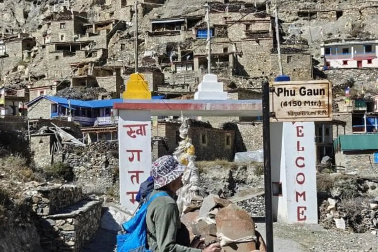 A trekker arriving at the stone-built village of Phu Gaun with traditional tea houses on the Annapurna Circuit Trek Tour.